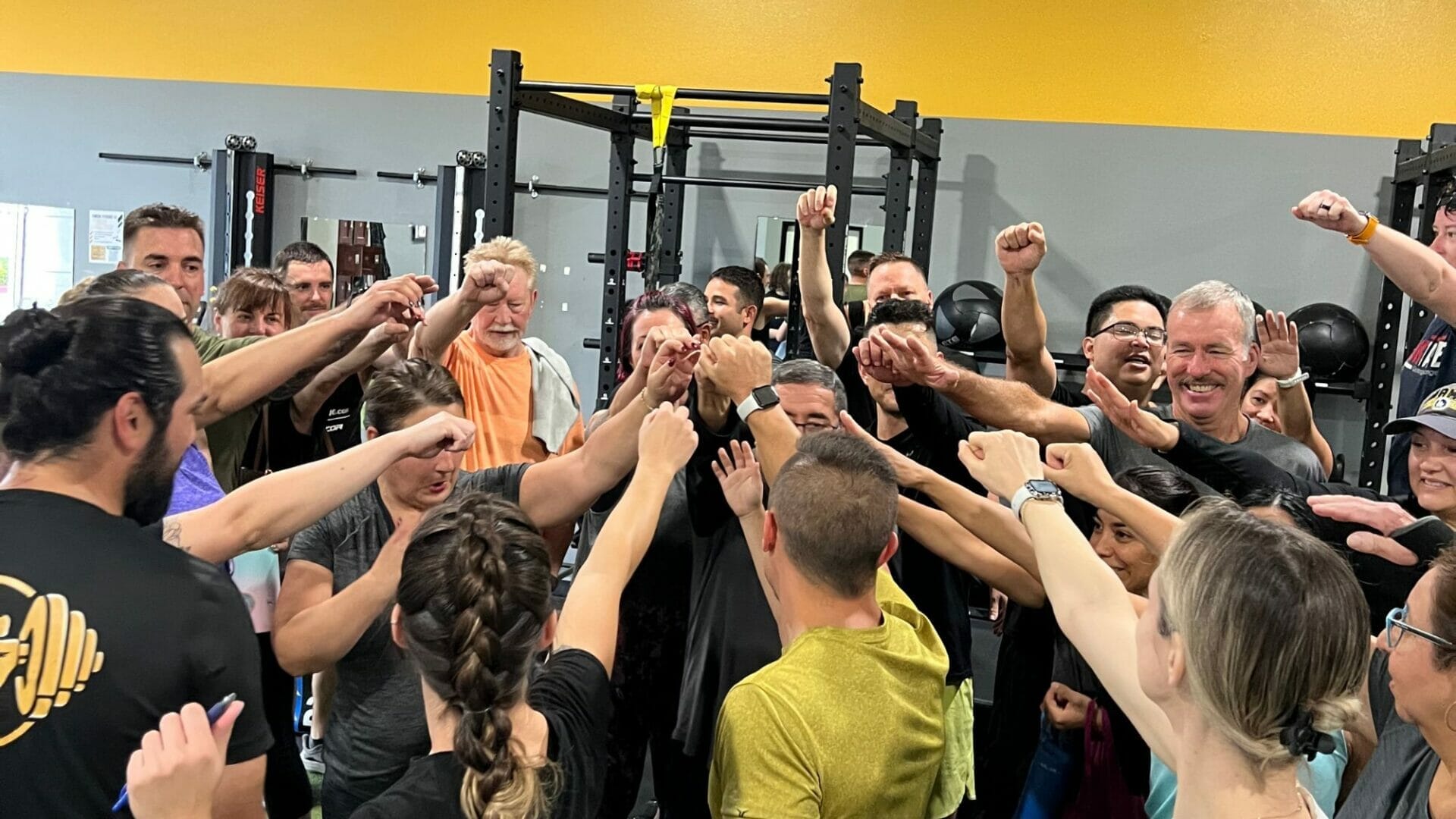 Group of Finish Strong 50 Fitness Challenge participants bringing it in after a group workout